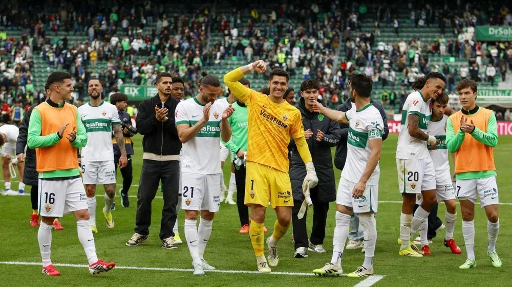 Los futbolistas del Elche celebran la trascendental victoria frente al Mallorca junto a su afición, en el Martínez Valero.